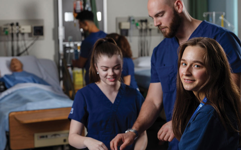 Nursing students working in a hospital room